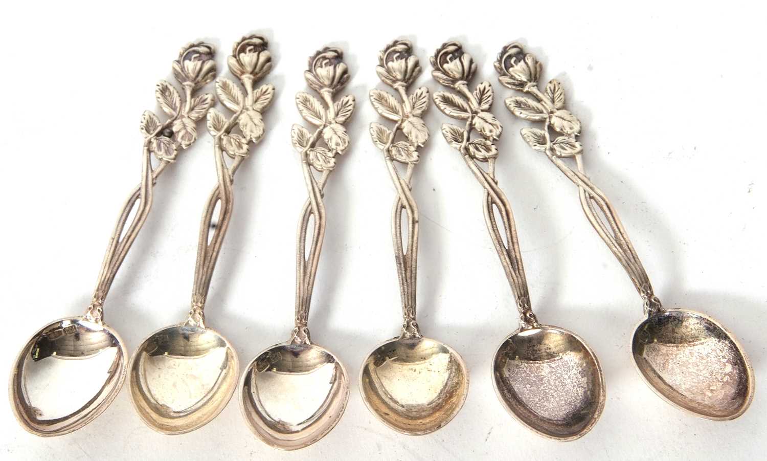 A cased set of six silver Russian teaspoons with decorative floral and leaf handles, the bowls