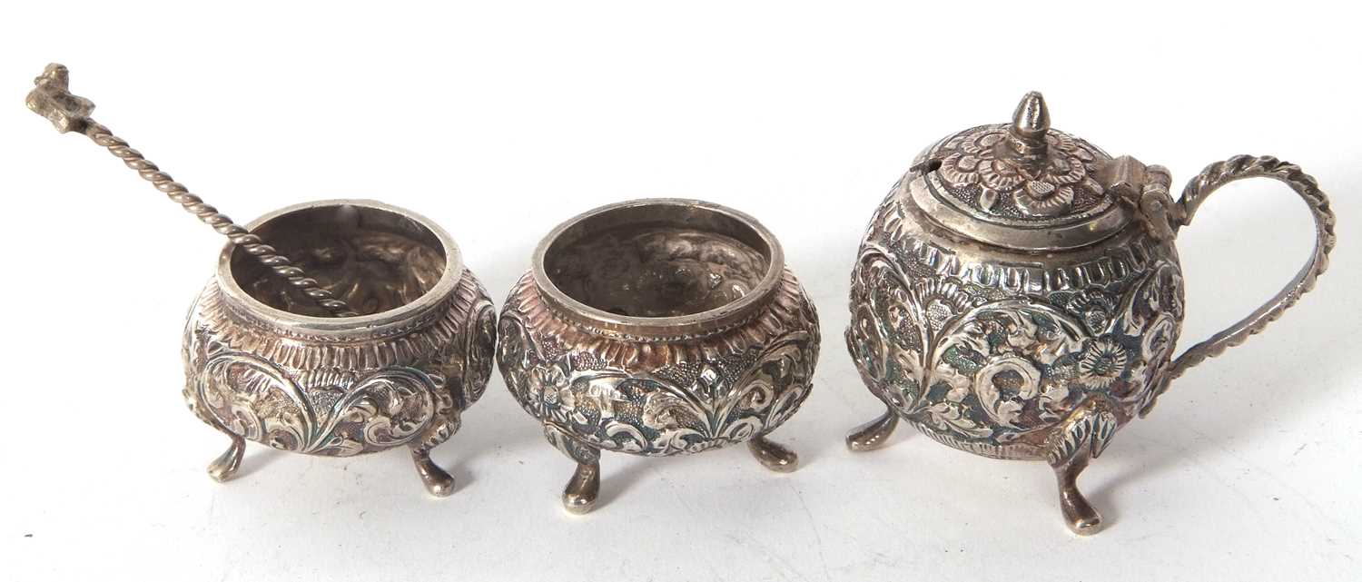An antique Indian kutch silver three piece condiment set comprising of two open salts and a hinged