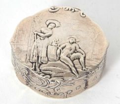 A white metal Dutch oval shaped box embossed to the lid with a pair of figures in a garden