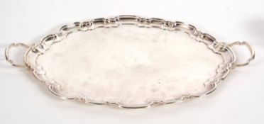 An Elizabeth II large silver twin handled tray of plain form having a pie crust border and twin cast