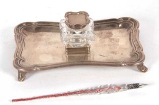 A late Victorian silver ink stand of shaped rectangular form, having reeded edges and supported on