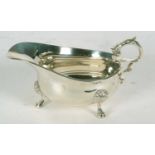 A George V silver sauce boat of typical form having reeded rim and flying leaf capped handle,