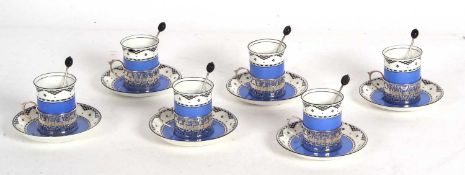 Six Art Deco George Jones porcelain coffee cans and saucers, the cans with hallmarked silver pierced