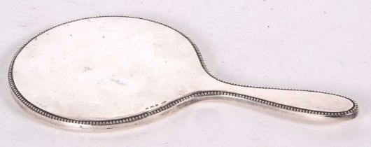 A hallmarked silver backed mirror of plain design with beaded edge, marks rubbed