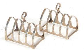 A pair of Art Deco silver toast racks of lancet form having four divisions with central carrying
