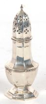 An Edwardian silver caster of octagonal form, pull off pierced lid with urn finial, standing on a