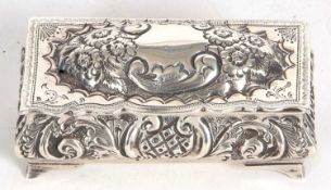 An Edwardian silver trinket box of sarcophagus form, having an embossed hinged dome lid with