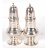 Pair of silver casters of baluster form reeded bodies with pull off pierced lids, London 1913,