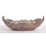 George V silver dish of boat shape having pierced scroll decorated sides and ornate scroll twin
