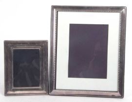 A large silver plated photograph frame of rectangular form, easel backed, 29 x 24cm together with