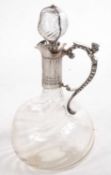 A Victorian glass and silver mounted claret jug, the dimpled glass body with a wrythen design having
