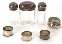 Mixed Lot: Three hallmarked silver serviette rings, three faceted glass dressing table jars with