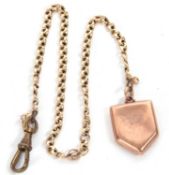 A yellow metal merchant link watch chain suspending a back and front shield locket with metal swivel