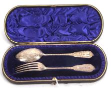 A late Victorian silver christening spoon and fork, chased and engraved all over, hallmarked for