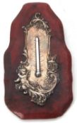 A late Victorian silver mounted thermometer on a red leather frame, embossed and chased with