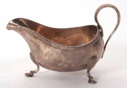 A George III Irish silver sauce boat, a gadrooned border having a reeded and chased detail handle,