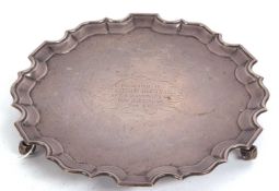 A George V silver salver of circular form with a raised pie crust rim, the centre with a