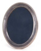 A modern silver photograph frame of oval form having a gadrooned rim and easel backed, Sheffield
