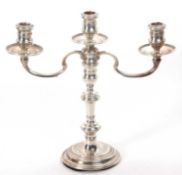 A silver three light candelabra standing on a plain circular foot, the column with three knops,