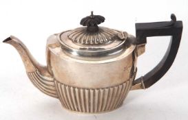 A late Victorian silver bachelors teapot with part fluted decoration, having ebonised finial and