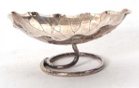A Chinese export white metal lily pad dish on a textured ring turn support, makers mark Wang Hing