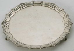 An Elizabeth II silver card salver of shaped plain circular form, applied gadrooned and shell