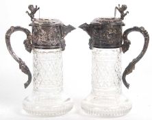 A pair of cut glass and silver plated Portuguese claret jugs having cut glass cylindrical bodies and