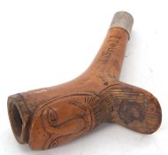 A vintage treen pipe, the bowl applied with a carved bearded mans face, the shaft marked J Snell Est