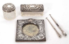 Mixed Lot: An Edwardian square silver mounted photograph frame, embossed with cherubs, scrolls and