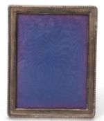 An Elizabeth II silver photograph frame of rectangular form with applied reeded border, 18 x 14cm,