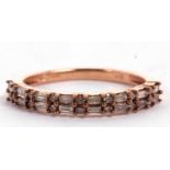 A 9ct rose gold and champagne diamond ring, the upper half set with two rows of alternating baguette