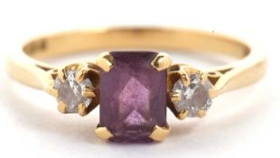 An 18ct amethyst and diamond ring, the rectangular radiant cut amethyst set to either side with a