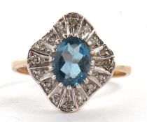 A 9ct topaz and diamond ring, the central oval topaz with an undulating surround of small round