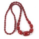 A 'cherry amber' bead necklace, the graduated oval beads between 7 - 22mm diameter, approx. 80cm