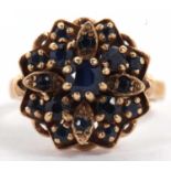 A 9ct sapphire cluster ring, the stepped flowerhead style cluster set with round sapphires, with