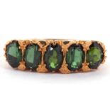 A 9ct green tourmaline ring, the five oval green tourmaline's, claw set with a scrolled gallery