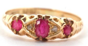 An 18ct ruby and diamond ring, the central oval ruby set to either side with diamond hightlights and