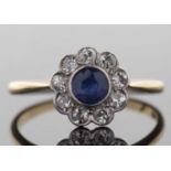 An Edwardian 18ct sapphire and diamond ring, the central round sapphire, collet mounted and