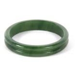 A nephrite bangle, the 14mm wide bangle with a central carved groove, inner diameter, 6.5cm, 51gGood