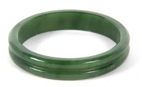 A nephrite bangle, the 14mm wide bangle with a central carved groove, inner diameter, 6.5cm, 51gGood