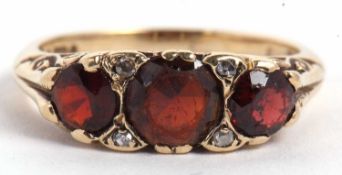 A 9ct garnet and diamond ring, the three round graduated garnets set with diamond highlights, with