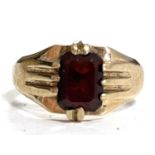 A 9ct garnet ring, the emerld cut garnet, claw mounted with tapered, ridged shoulders and plain band