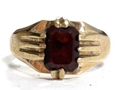 A 9ct garnet ring, the emerld cut garnet, claw mounted with tapered, ridged shoulders and plain band