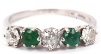 A diamond and emerald five stone ring featuring three graduated old cut diamonds, 0.65ct approx