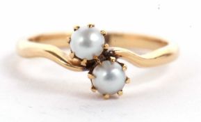 An 18ct cultured pearl crossover ring, the two pearls, claw mounted to a crossover style band