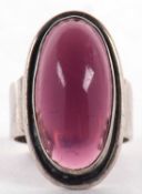 A Danish silver ring, set with an oval purple stone, collet mounted, 27mm x 15mm , with slightly