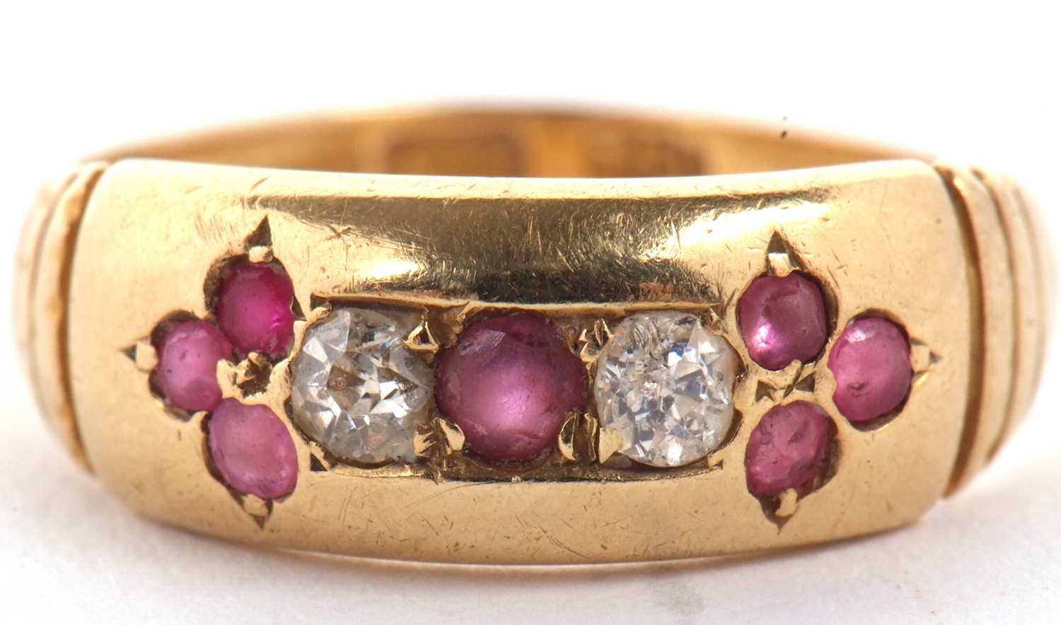 An 18ct ruby and diamond ring, the central round ruby set to either side with a round diamond and - Image 2 of 8