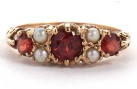 A 9ct garnet and cultured pearl ring, the three graduated round garnets interspaced with two small