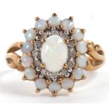 A 9ct opal and diamond cluster ring, the central oval opal cabochon surrounded by small round