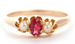 A 14k ruby and cultured pearl ring, the oval ruby set to either side with a cultured pearl, all claw